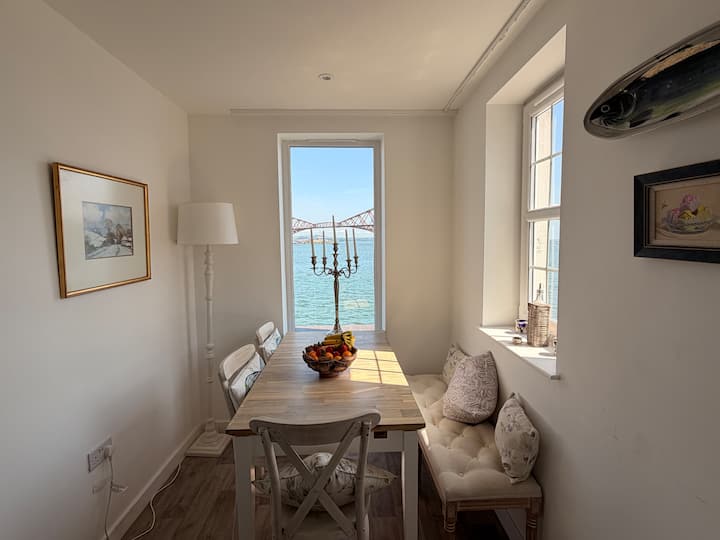Dining table beside a window overlooking the Forth bridges